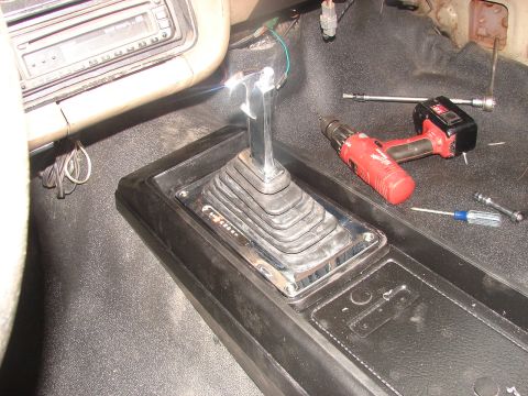 1973 Ford Ranchero - Interior view of a vehicle's center console, showing a chrome shifter and tools for repair.