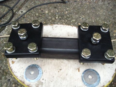 1989 Ford Bronco - This metal bracket assembly is secured with eight bolts and washers, attached to a dark rectangular bar.