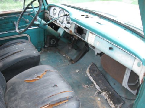1966 Ford F-250 - The interior of a vintage truck shows significant wear and tear on the seats and dashboard.