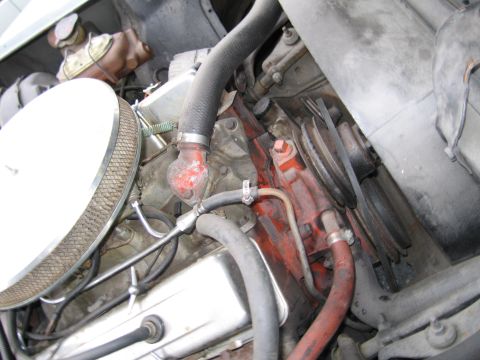 1991 Ford LTD Crown Victoria - Close-up view of an engine bay, showing an air filter, various hoses, and a red-painted engine block.