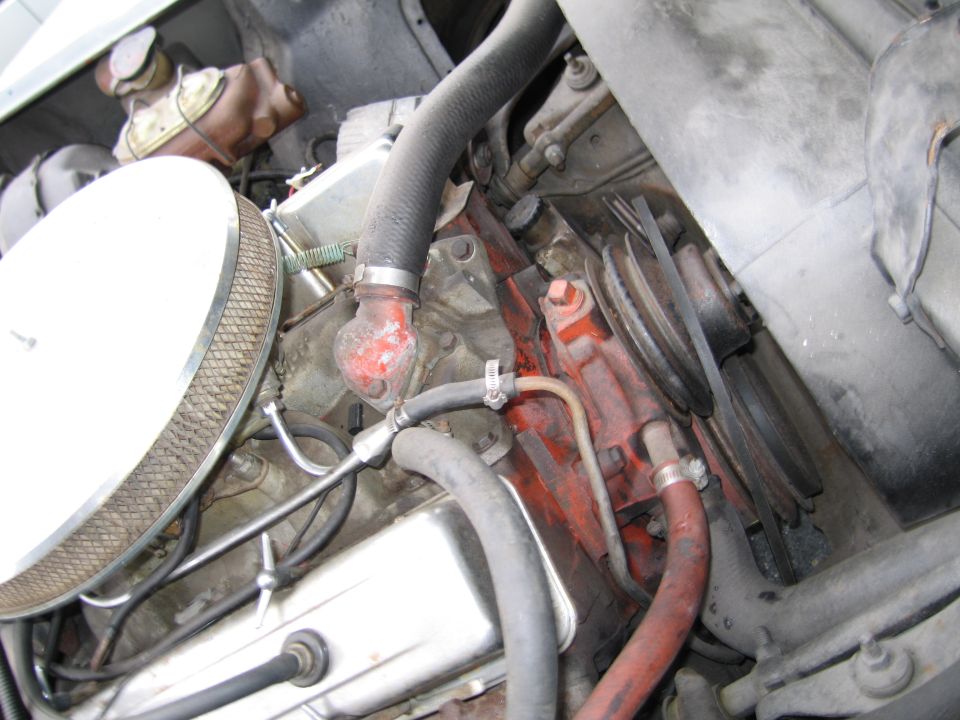 Engine bay with air filter, hoses, and red-painted engine block