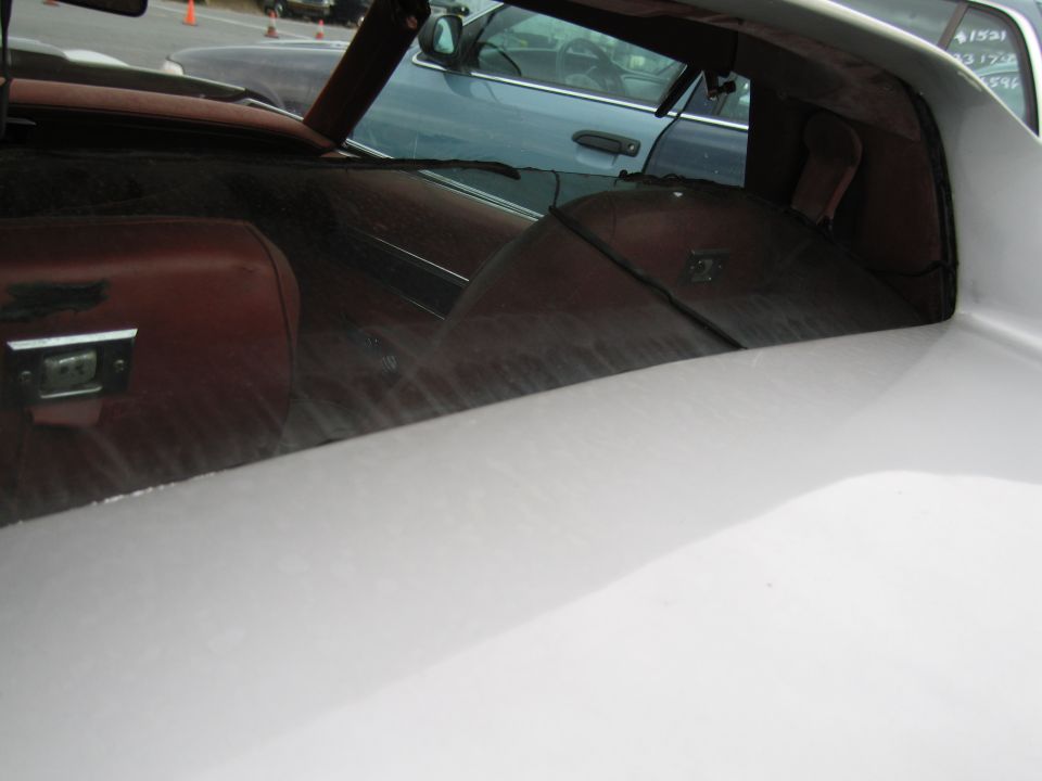 Interior view of a white car with brown seats, showing a blue car through the window