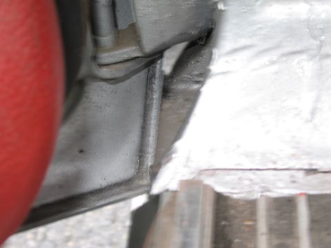 1991 Ford LTD Crown Victoria - Detail shot of a vehicle's undercarriage, showing a red hose and metal components.