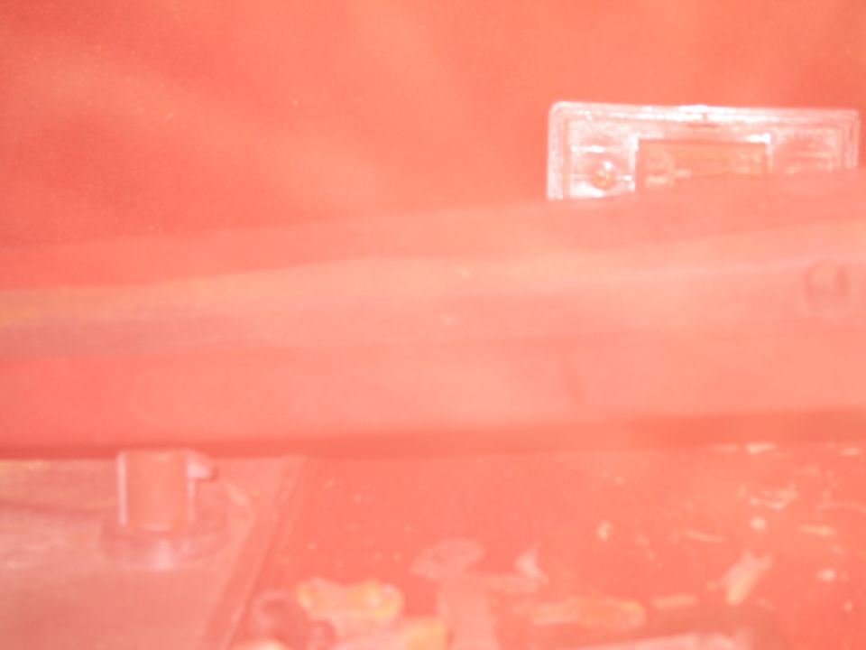 Close-up of a clear plastic part with a screw, likely from a car interior