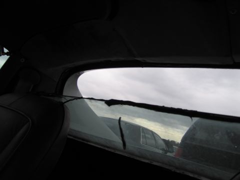 1991 Ford LTD Crown Victoria - View from inside a car's interior, looking out the rear window at other vehicles in a lot.