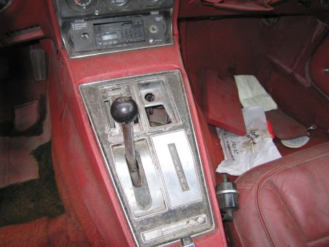 1991 Ford LTD Crown Victoria - The interior of a car features a red center console with an automatic transmission shifter and radio.