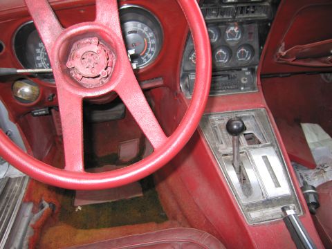 1991 Ford LTD Crown Victoria - The interior of the car features red upholstery and a worn dashboard with multiple gauges.