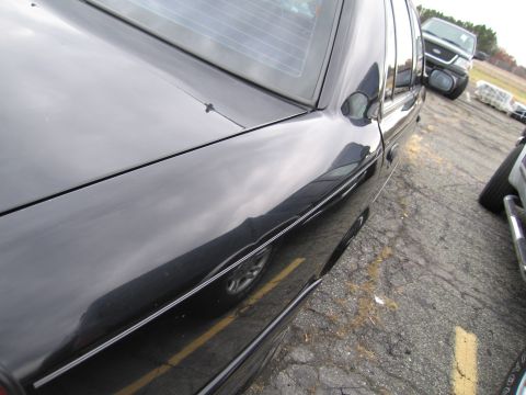 1991 Ford LTD Crown Victoria - A black sedan is parked in a lot next to other vehicles, with a Ford Explorer visible in the background.