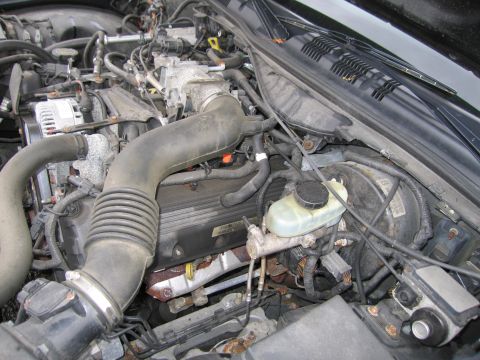 1991 Ford LTD Crown Victoria - Close-up view of a car's engine bay, showing various mechanical parts and wiring.
