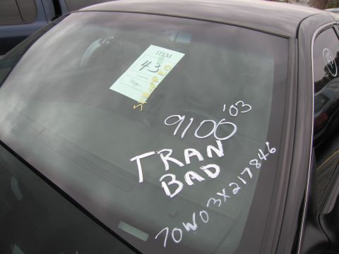 1991 Ford LTD Crown Victoria - A car's windshield displays a temporary tag and handwritten notes, possibly indicating its condition or sale details.