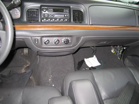 1991 Ford LTD Crown Victoria - The interior of a car shows the dashboard, climate controls, and seats, with some wiring exposed under the dash.