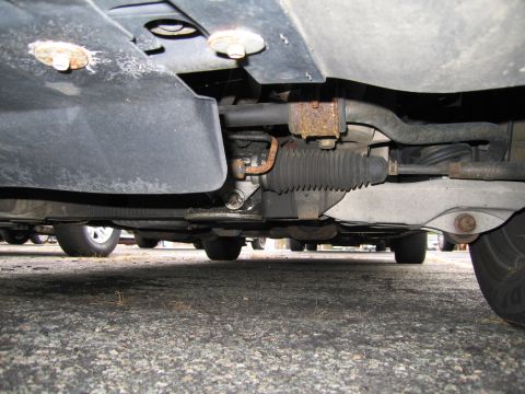 1991 Ford LTD Crown Victoria - Underside view shows the steering rack and suspension components of a vehicle.