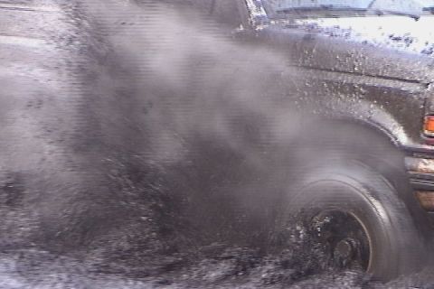 1993 Ford Bronco - Ford Bronco driving through mud, splashing water and dirt.