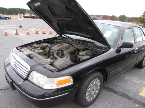 1991 Ford LTD Crown Victoria - Front view of a black sedan with the hood open, revealing the engine compartment.