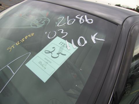 1991 Ford LTD Crown Victoria - Writing on a car's windshield indicates it has been stripped and has some identifying numbers.