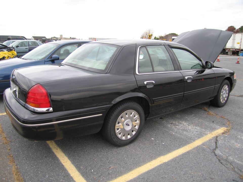 1991 Ford Crown Victoria LTD parked in lot, hood up. Another car is parked next to it