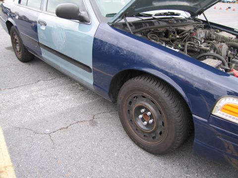 1991 Ford LTD Crown Victoria - A blue Ford Crown Victoria with its hood open, revealing the engine compartment. The front fender is a different shade of blue.