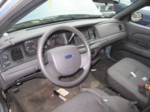 1991 Ford LTD Crown Victoria - Interior view of a car, showing the dashboard, steering wheel, and seats. The hood is open.