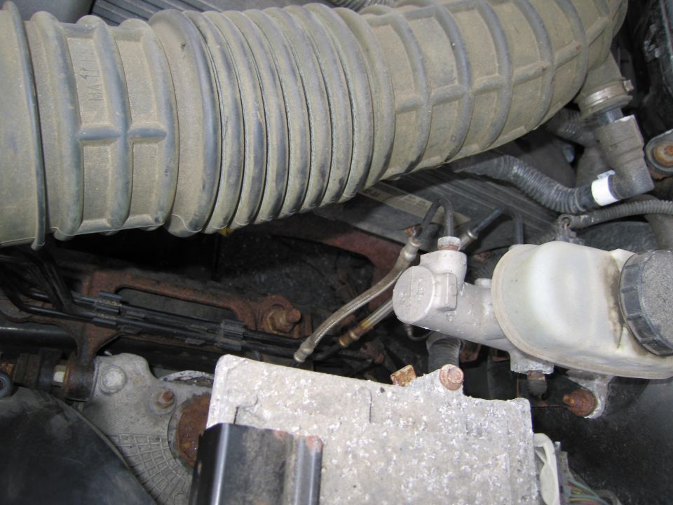 Engine bay view of brake master cylinder and air intake hose