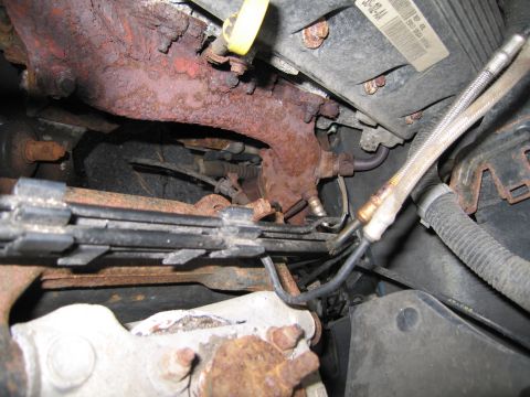 1991 Ford LTD Crown Victoria - The image shows heavily rusted engine components, including an exhaust manifold and various hoses and wires.