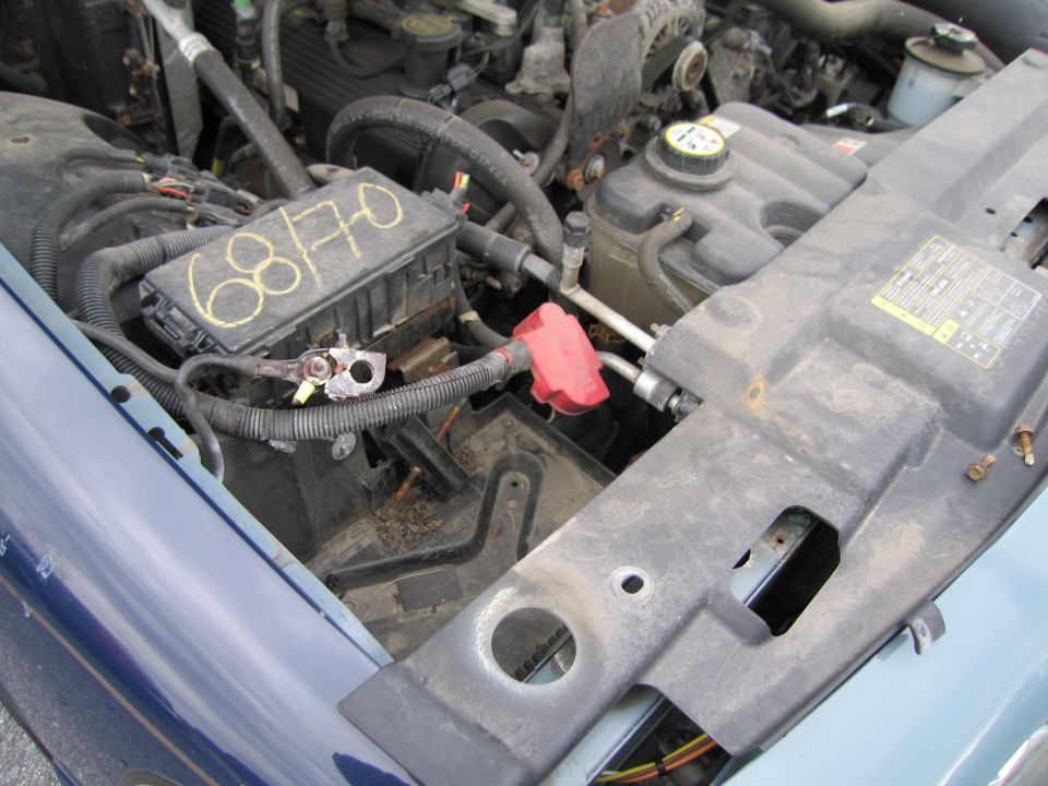 Engine bay showing fuse box with handwritten '68/70' and red battery terminal