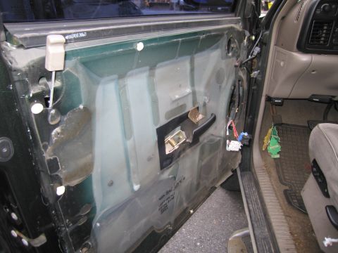 1991 Ford LTD Crown Victoria - The interior of a car door is exposed, revealing its inner workings and components.