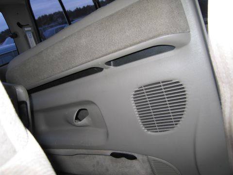 1991 Ford LTD Crown Victoria - Close-up view of a vehicle's interior door panel, showing a speaker grille and part of a fabric seat.