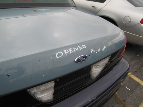 1991 Ford LTD Crown Victoria - The trunk of a 1991 Ford Crown Victoria LTD has "OPENED PICK UP" spray-painted on it.