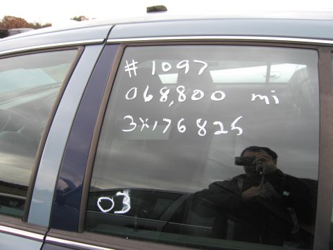 1991 Ford LTD Crown Victoria - White markings on a car's rear window include a number, mileage, and other codes.