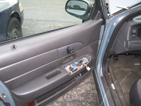 1991 Ford LTD Crown Victoria - Interior view of a car with exposed wiring on the door panel, and another vehicle visible through the window.