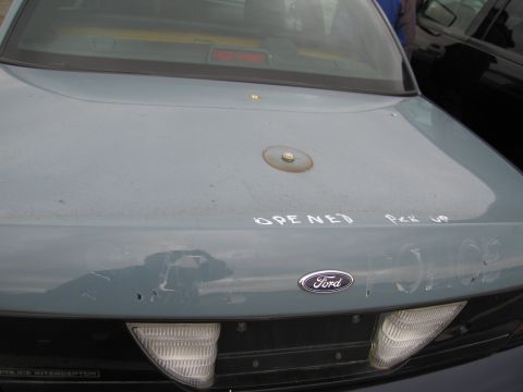 1991 Ford LTD Crown Victoria - The rear of a light blue Ford sedan shows handwritten text on the trunk, including "OPENED Pick UP" and "POLICE".