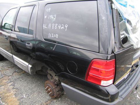 1991 Ford LTD Crown Victoria - A black SUV is missing a rear wheel, with handwritten markings on the rear window.