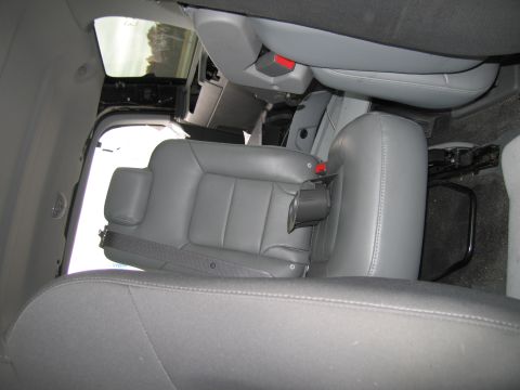 1991 Ford LTD Crown Victoria - The interior of a vehicle shows gray leather seats with visible seatbelts and a cup holder.