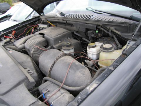 1991 Ford LTD Crown Victoria - Engine bay view showing the Triton 5.4 V8 engine cover and air intake system. Another vehicle is partially visible in the background.