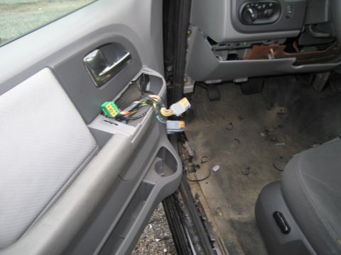 1991 Ford LTD Crown Victoria - The interior of a vehicle shows exposed wiring and connectors on the door panel and dashboard area.