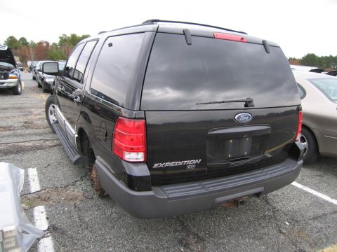 1991 Ford LTD Crown Victoria - Rear view of a black Ford Expedition SUV parked outdoors, missing its rear tire.