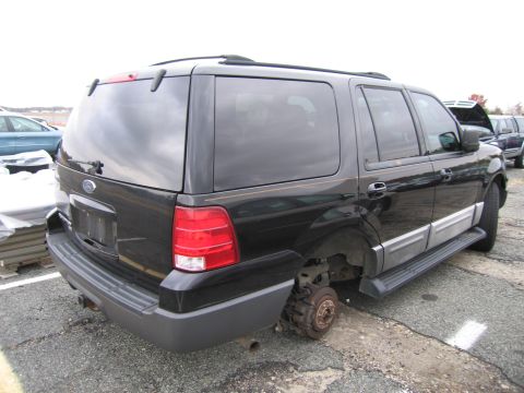 1991 Ford LTD Crown Victoria - This black SUV is missing a wheel and appears to be in a storage lot.