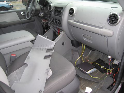 1991 Ford LTD Crown Victoria - The interior of a car shows a disassembled dashboard with exposed wiring and a removed panel resting on the seat.