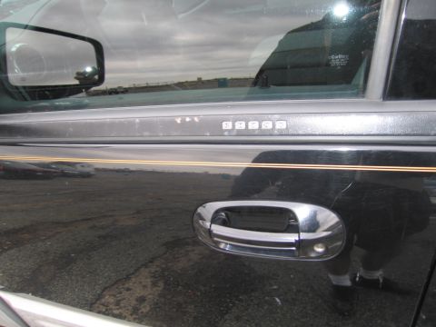 1991 Ford LTD Crown Victoria - The side of a dark-colored vehicle is shown, a chrome door handle and a keypad for entry.