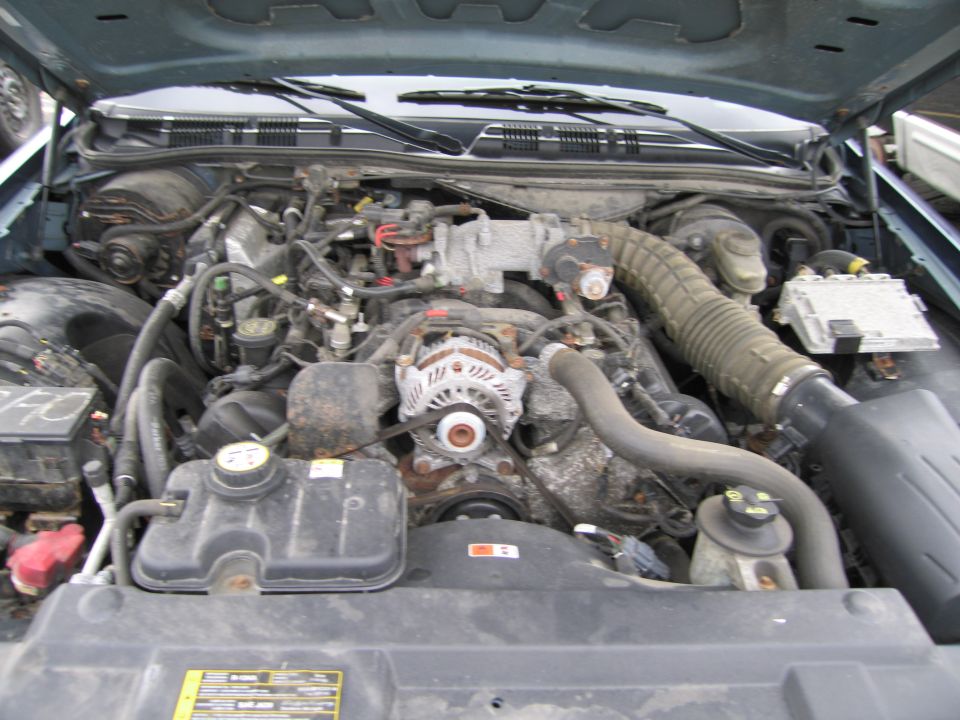 Engine bay of a Ford Crown Victoria. Shows the V8 engine, alternator, and coolant reservoir