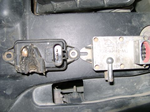 1998 Ford Crown Victoria - A close-up shows two DPFE sensors, one of which has significant heat damage to its plastic casing.