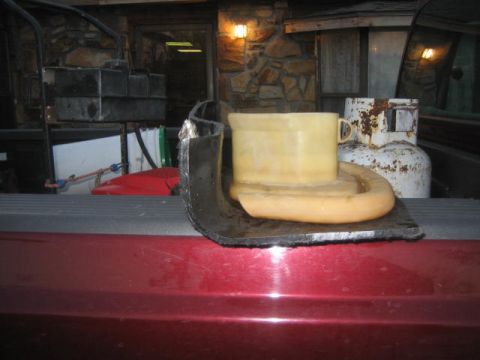 1996 Ford Thunderbird - A yellow plastic part and a propane tank are visible in the bed of a red pickup truck.