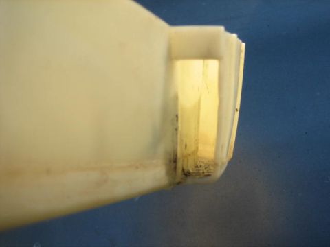 1996 Ford Thunderbird - Close-up of a plastic fluid reservoir, likely for a vehicle's coolant or washer fluid.