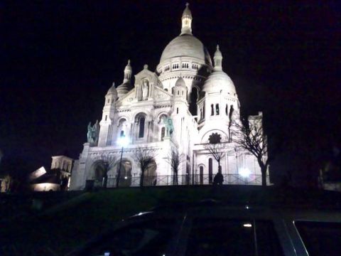 1991 Ford Crown Victoria - The Sacré-Cœur Basilica stands illuminated against the night sky, with bare trees and a hint of a vehicle in the foreground.