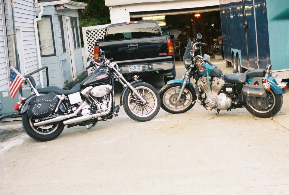 Black and teal Harley-Davidson cruisers parked nose-to-nose on a driveway