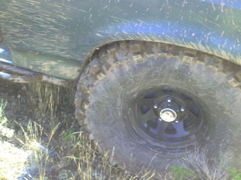 1989 Ford Bronco - Close-up of a dirty tire and fender, suggesting off-road use.