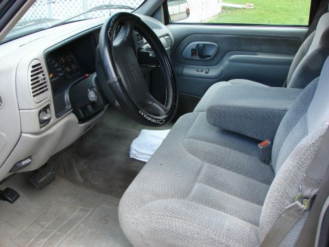 1984 Ford F-250 - The interior of a Chevrolet truck, gray cloth seats and a Chevrolet-branded steering wheel cover.