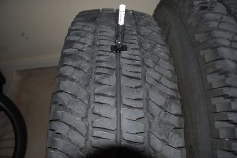 2000 Land Rover Range Rover - Measuring tire tread depth with a gauge.