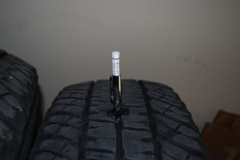 2000 Land Rover Range Rover - Measuring tire tread depth with a gauge. The gauge has markings for measurement.