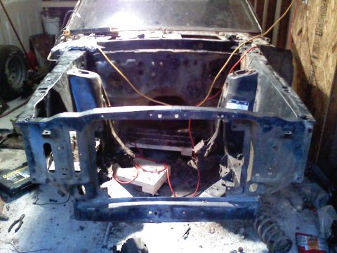 1969 Ford Mustang - The front end of a 1969 Ford Mustang is visible, stripped down and in a state of disrepair.